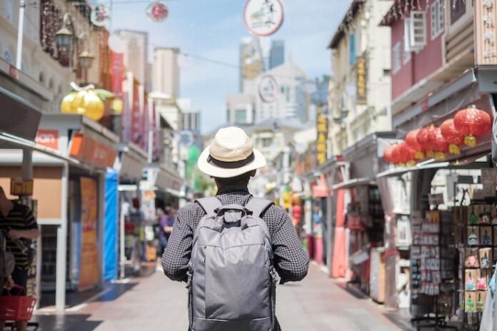 rear-view-man-wearing-hat-standing-street-city_1048944-10183169